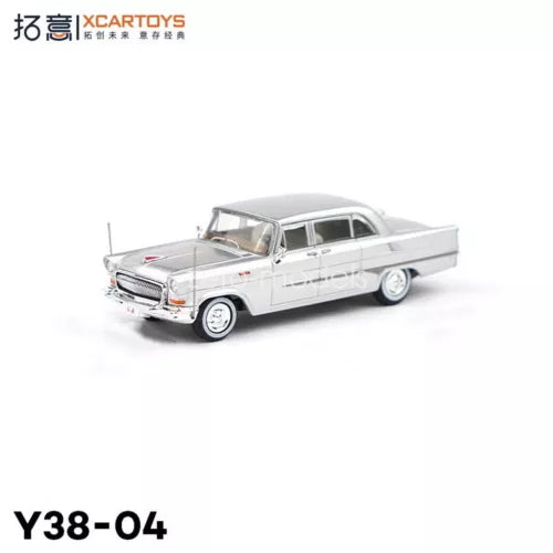 Silver diecast sedan car model with chrome grille and white interior