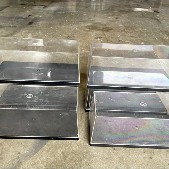 Clear diecast display case with hinged top and rectangular compartments, transparent lid