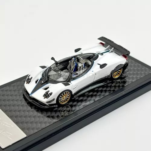 White 1:64 scale sports diecast car model with open cockpit detail on display base