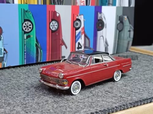 Vintage red diecast sedan model with chrome details and whitewall tires