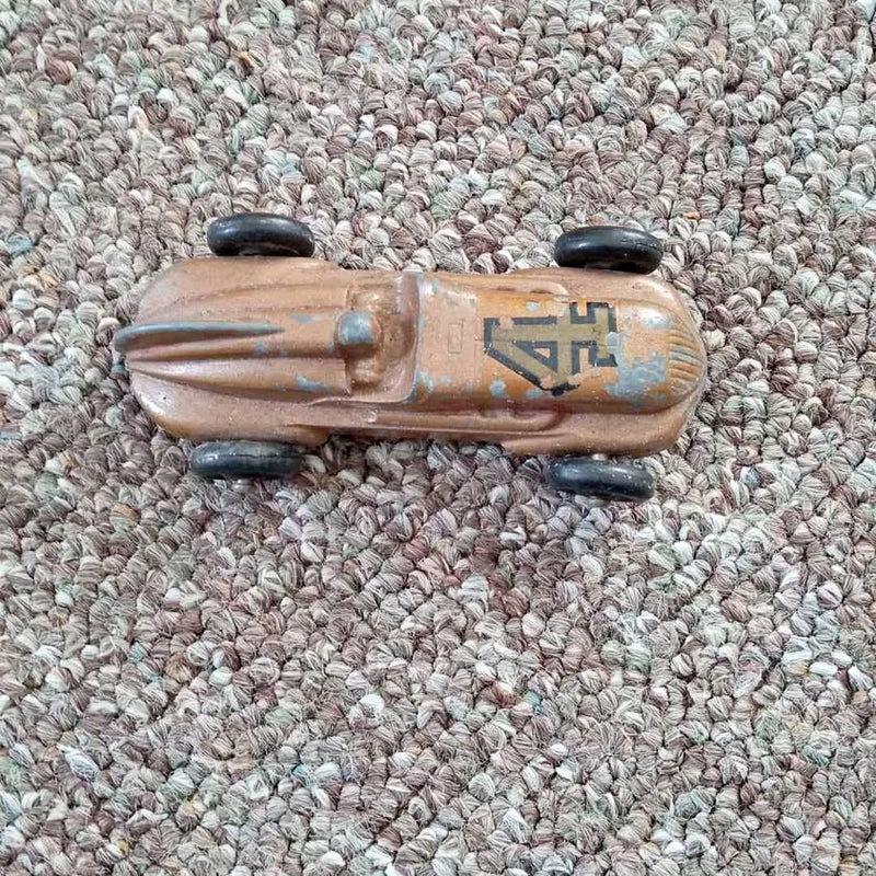 Metallic tan diecast race car with blue decals and black wheels