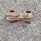 Metallic tan diecast race car with blue decals and black wheels