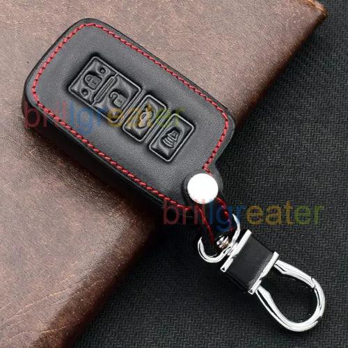Brown leather key fob cover with red stitching, embossed buttons and keyring.