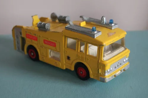 Vintage yellow diecast fire tender truck with side cab and roof equipment