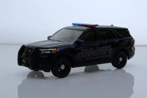 Police SUV diecast model with black body, roof lights, blue stripes, front 3/4 view
