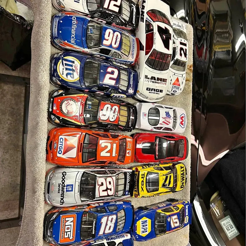 Diecast car collection with numbered race cars in blue, red, orange, and white
