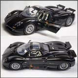 1:24 scale diecast model car in dark black, open cockpit detail, two-angle view