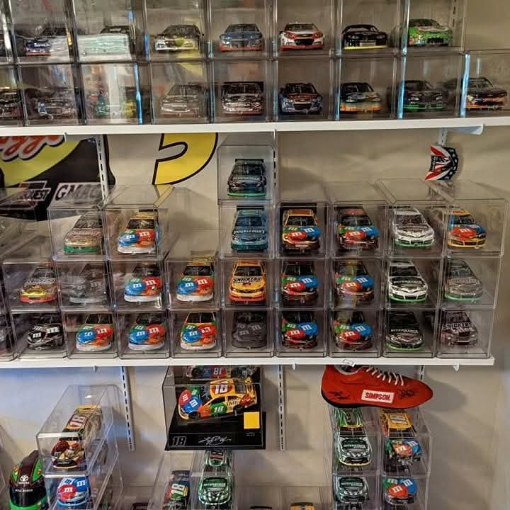 Diecast model car display case with multiple miniature race cars in clear compartments