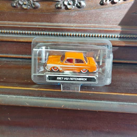 1967 VW Notchback diecast model in clear display case, orange car