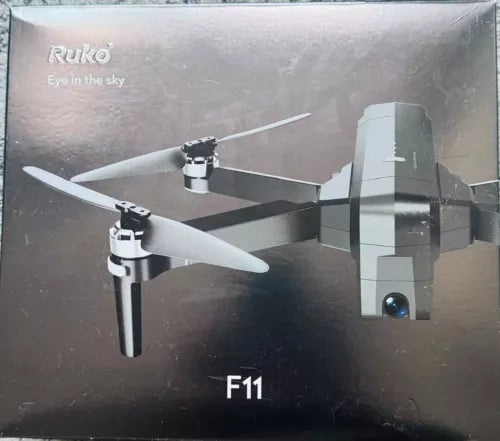 Black quadcopter drone with white propellers, F11 label visible on the box