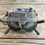 Gray quadcopter drone with front sensors, side prop arms, and landing skids