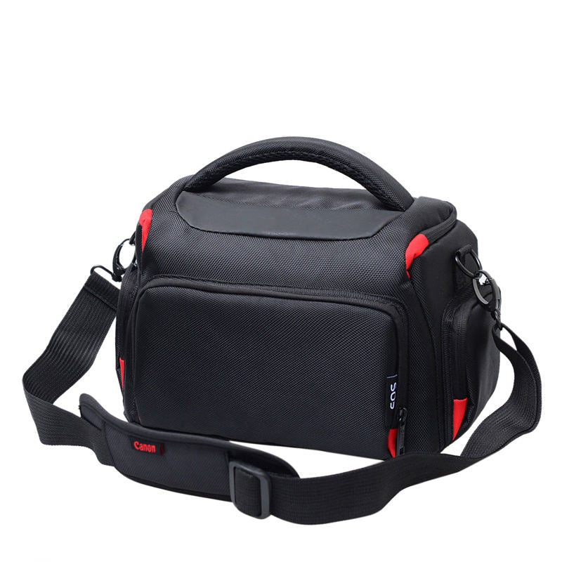 Black waterproof camera crossbody bag with padded handle, shoulder strap, and red trim