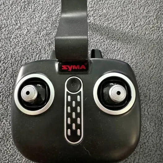 Drone controller with dual thumb joysticks and SYMA logo