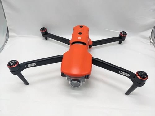 Orange and black quadcopter drone with four rotors and centered front camera