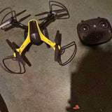 Yellow and black quadcopter drone with camera and four propellers, with remote controller