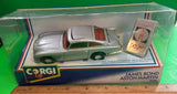 Silver diecast model car with brown interior in clear display box