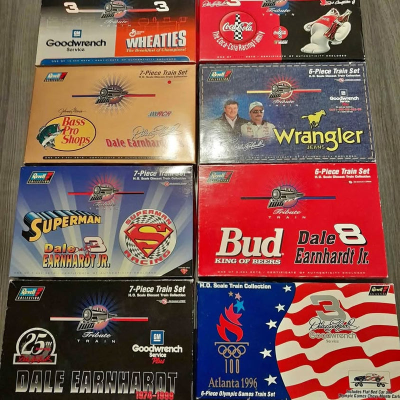 Assorted boxed diecast train sets with racing sponsor graphics and logos