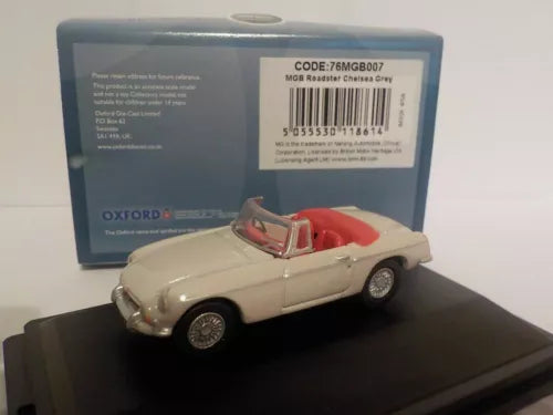 Diecast roadster model car, cream body with red interior, on black display base
