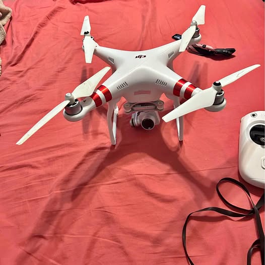 DJI Phantom 3 drone with 4 propellers and attached camera, white body