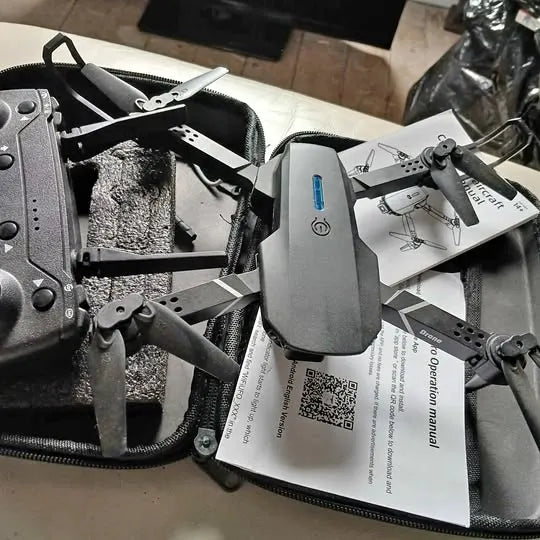 Foldable drone with camera and attached propellers in packaging insert