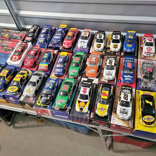 Boxed diecast race car collectibles, assorted drivers on display