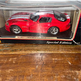 Red diecast sports car model in clear display case, front three-quarter view
