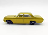 Vintage diecast sedan car with trailer hitch, gold/yellow