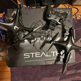 Quadcopter drone with four propellers and dark gray body, with controller