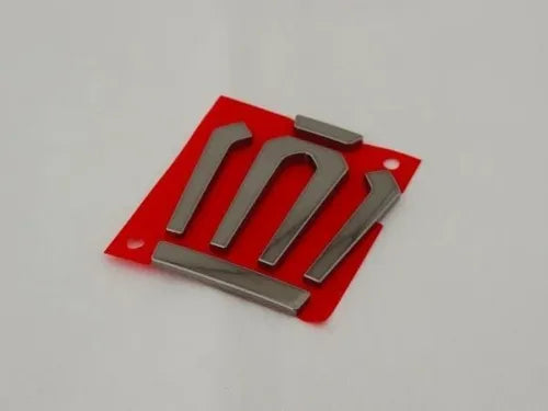Red and silver diecast car emblem with raised chrome letters