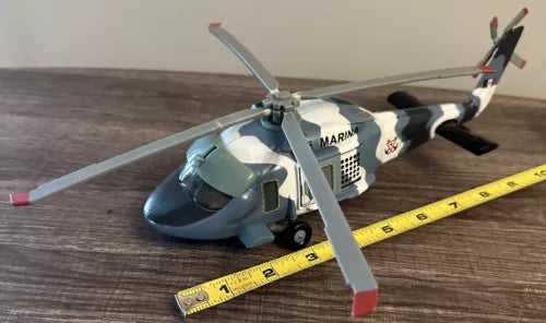 Diecast toy helicopter with blue and black body, MARINA text, spinning rotor blades