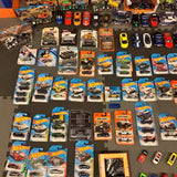 Hot Wheels diecast car and truck lot, boxed vehicles on display