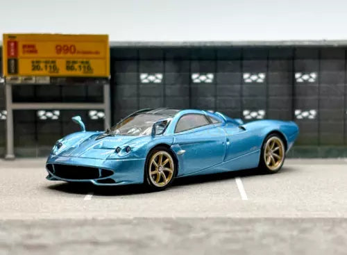 Ice blue sports diecast car with gold wheels, low aerodynamic body, side view.