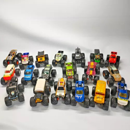 Assorted 1:64 diecast monster trucks with colorful painted bodies and oversized tires