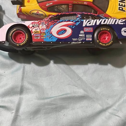 Diecast race car with Valvoline blue-and-red graphics and red wheel rims