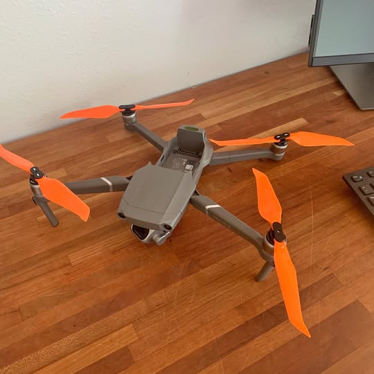 DJI Mavic 2 Pro drone with orange propellers and grey body, landing gear extended