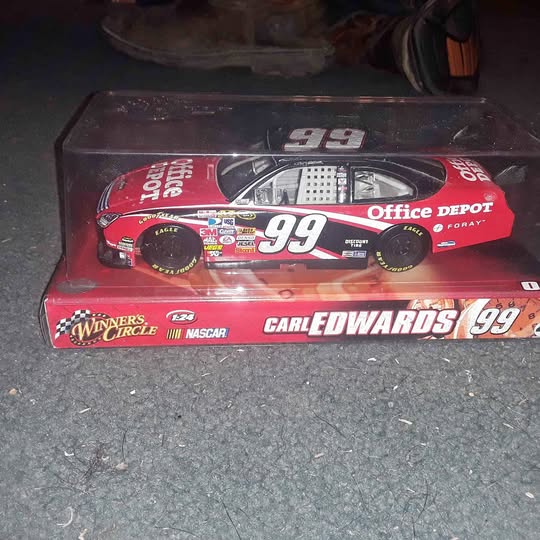 1:24 scale diecast race car #99 in clear display case, red and black
