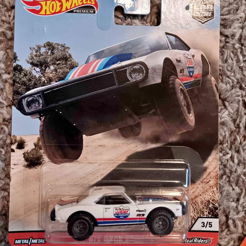 Hot Wheels off-road diecast Camaro, white with blue and red stripes, raised front view