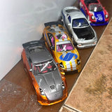 Diecast race car toy, orange with black hood and racing decals, front angled view