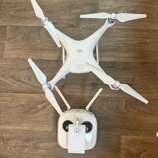 DJI Phantom 4 quadcopter drone with four propellers, white body