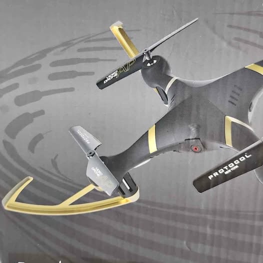 Gray quadcopter drone with yellow accents, four propellers and landing skids