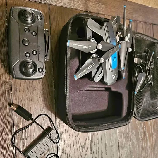 Folding quadcopter drone with remote controller and prop guards in a hard case