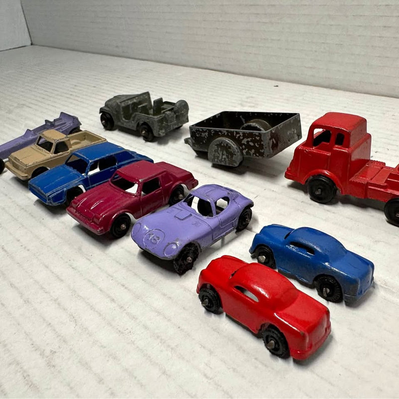 Assorted vintage diecast toy cars, red blue purple black and tan vehicles on display