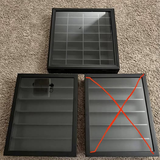 Black display case with glass lid and interior grid shelves, shown open
