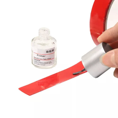 Primer bottle with applicator spreading a red strip for model car parts