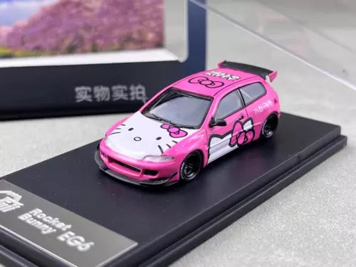 Pink and white diecast model car with sporty body kit on display base