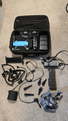 Drone accessory kit with black case, controller, batteries, and charger components
