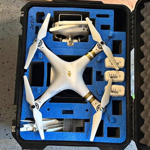 White quadcopter drone in black hard case with blue foam cutout inserts