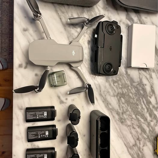 DJI Mini drone kit with remote controller, batteries, propellers, and charging parts