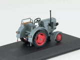 Diecast tractor model with gray body and red wheels, front view, raised exhaust pipe