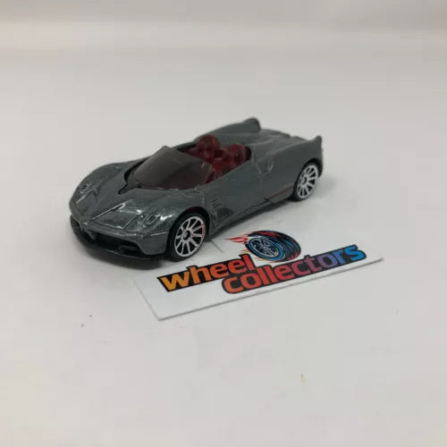 Diecast roadster model car in dark gray with open top, red interior, detailed wheels